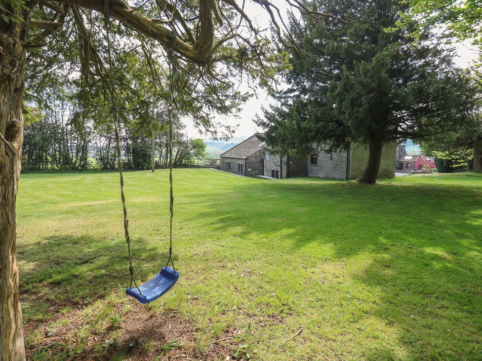 A swing hanging from a tree in an outdoor area at Stagwood House in New Mill