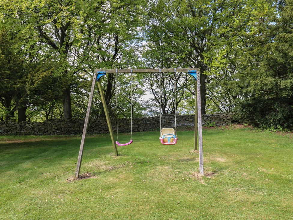 A swing set with two swings in a garden at Stagwood House in New Mill