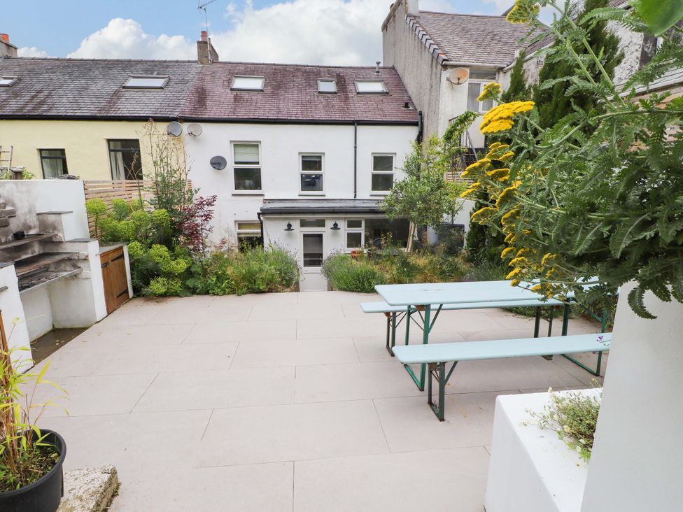A garden with a table and plants at Hendre in Menai Bridge