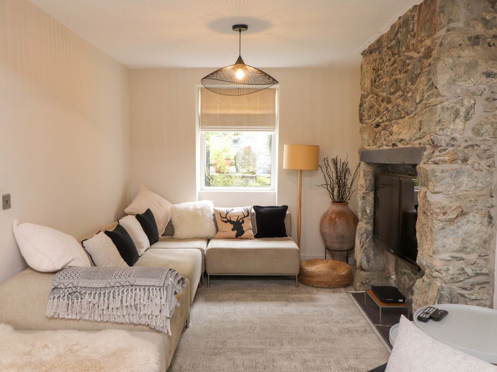 A living room with a sofa and television at Hendre in Menai Bridge