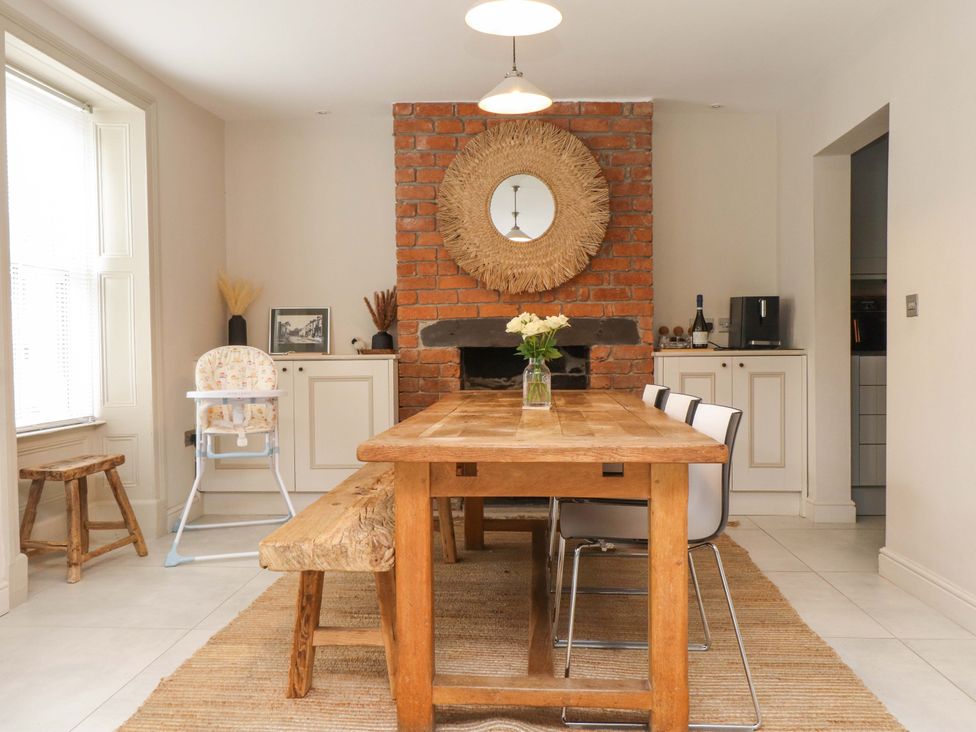 A dining room with a wooden table and chairs at Hendre in Menai Bridge