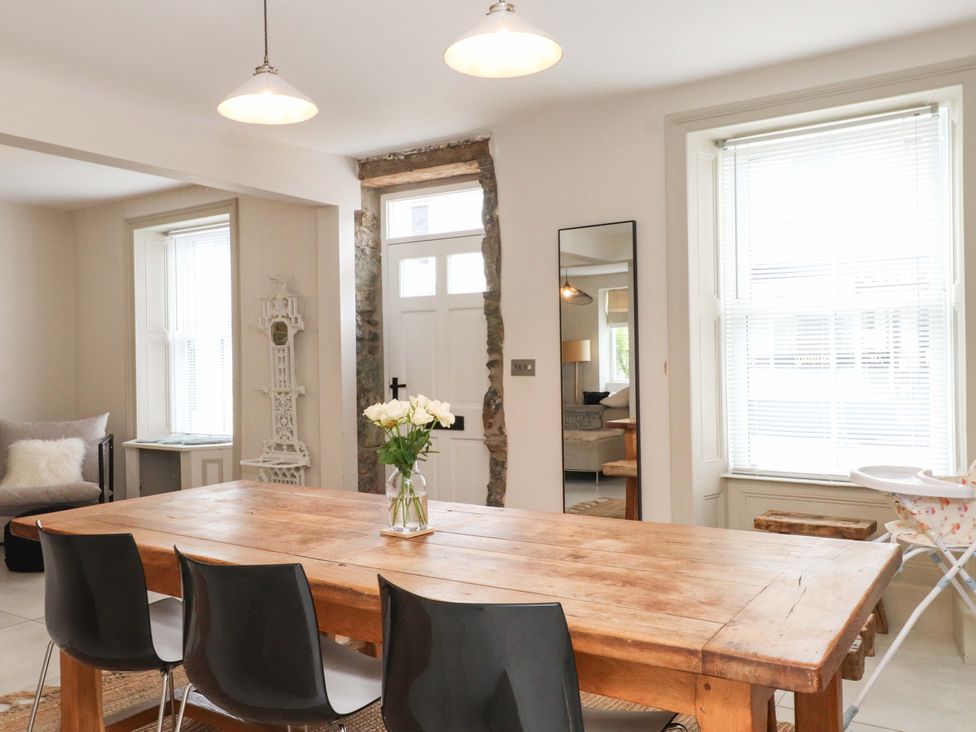 A dining room with a wooden table and chairs at Hendre in Menai Bridge