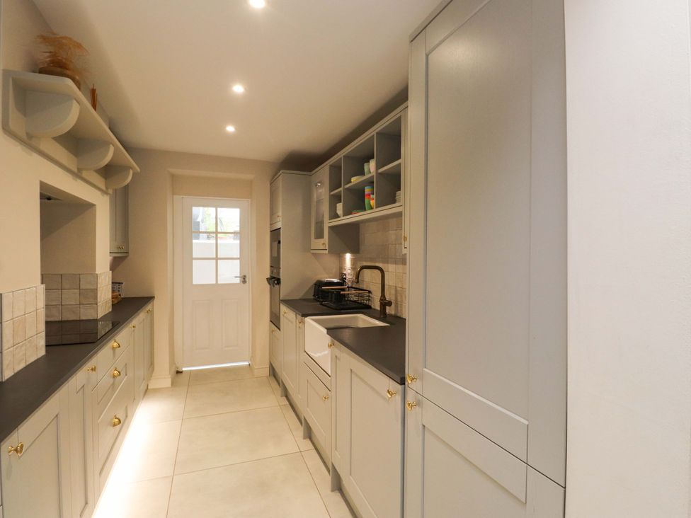 A kitchen featuring a sink and cabinetry at Hendre in Menai Bridge