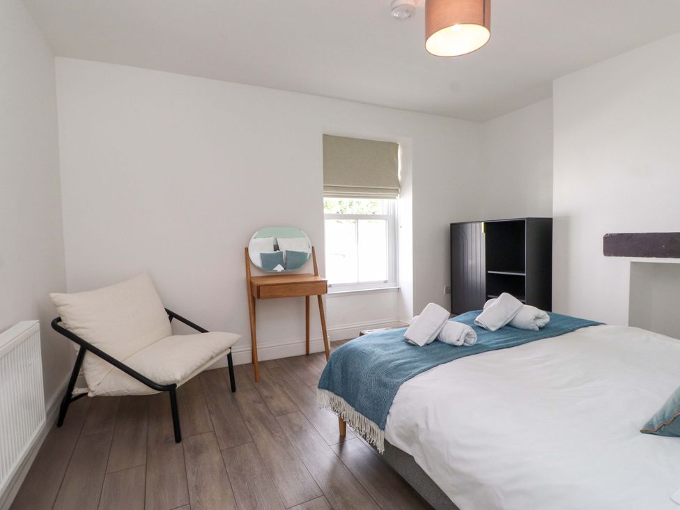 A bedroom with a bed and chair at Hendre in Menai Bridge