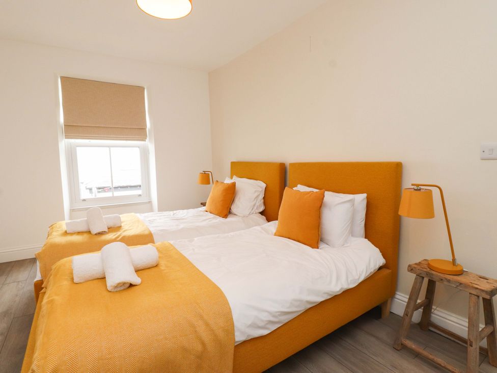 A bedroom with two beds and a window at Hendre in Menai Bridge