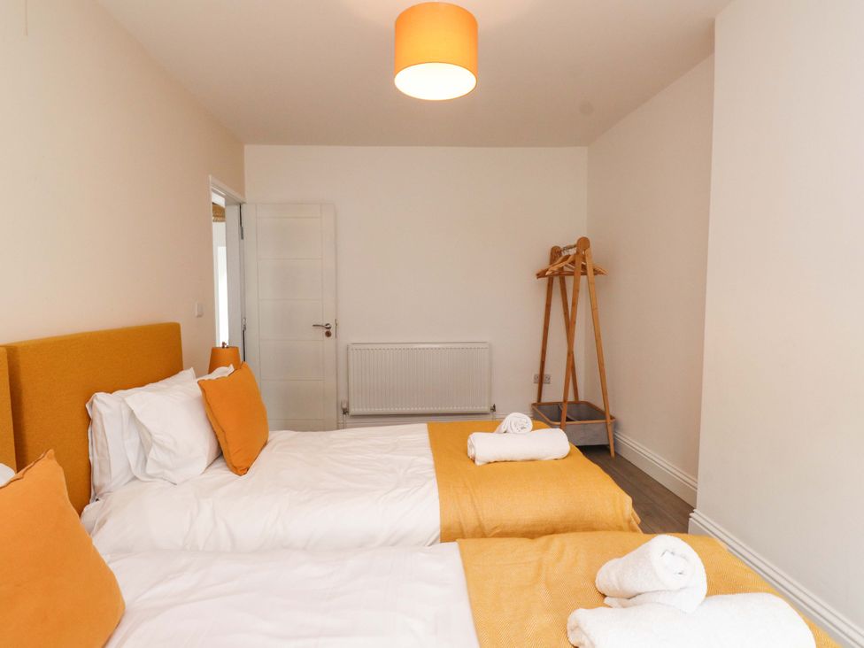 A bedroom with two beds and a coat rack at Hendre in Menai Bridge