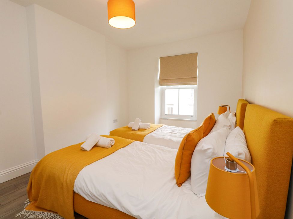 A bedroom with two beds and a window at Hendre in Menai Bridge