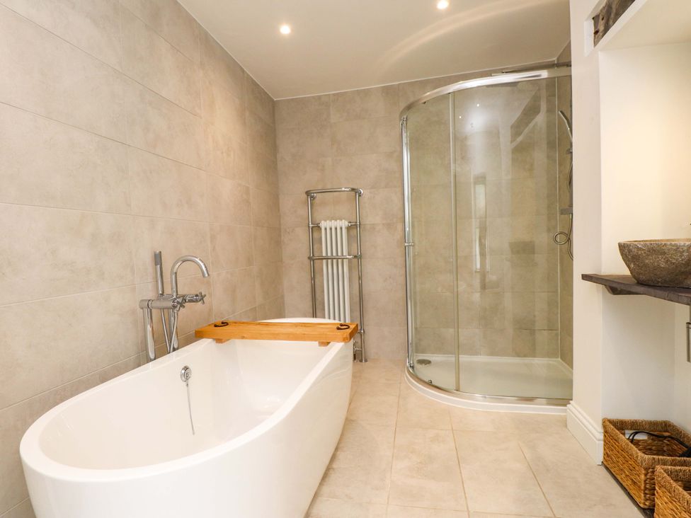 A bathroom with a bathtub and shower at Hendre in Menai Bridge