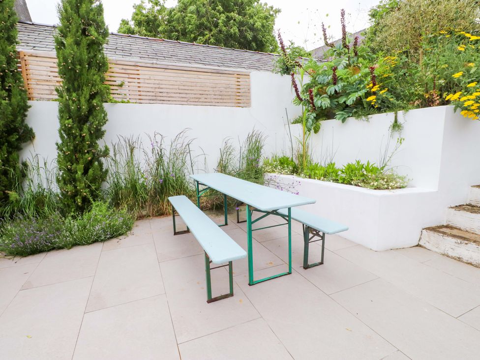 A garden with a table and benches surrounded by plants at Hendre in Menai Bridge