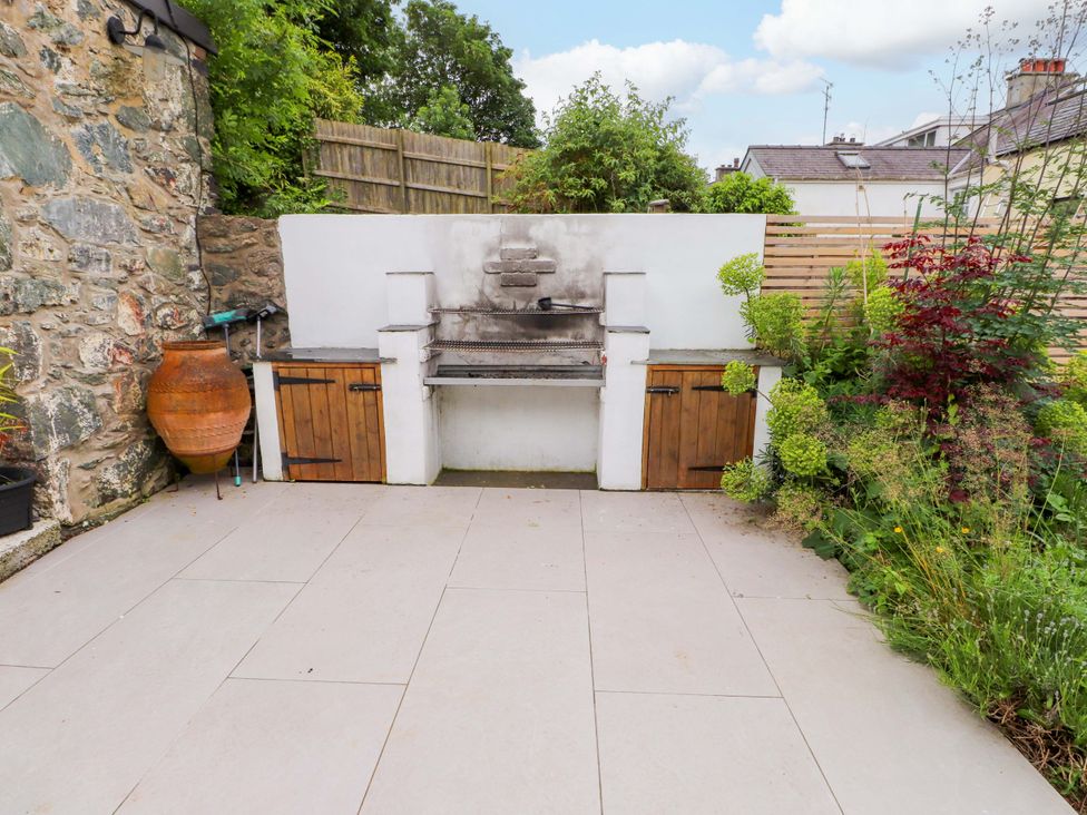 A garden with a grill and storage units at Hendre in Menai Bridge