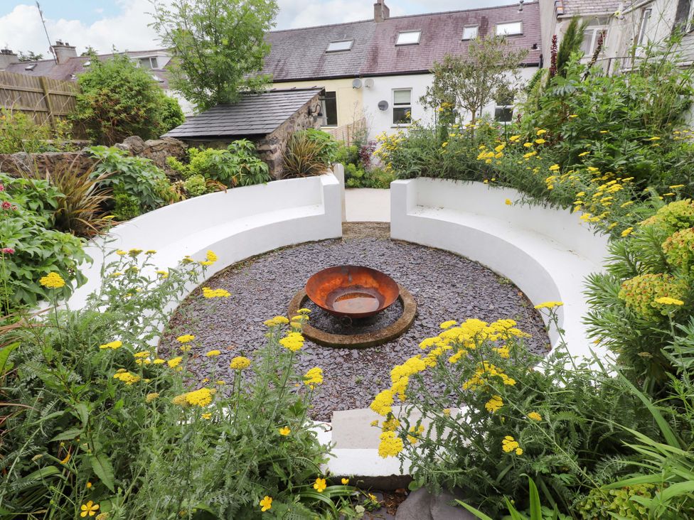 A garden with a fire pit and seating area at Hendre in Menai Bridge