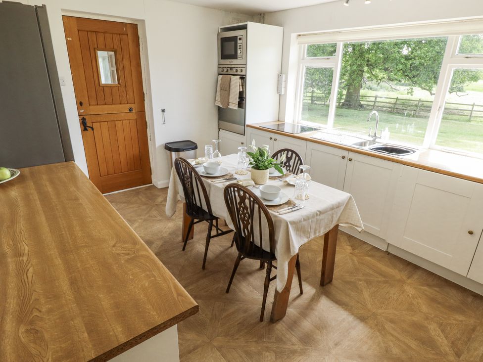 A kitchen with a dining table and chairs at Lake View Cottage in Well near Alford