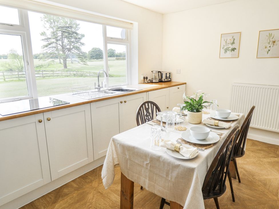 A kitchen with a dining table set for a meal at Lake View Cottage in Well near Alford