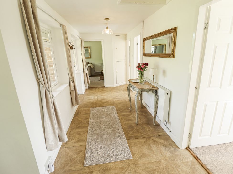 A hallway with a table and flowers at Lake View Cottage in Well near Alford
