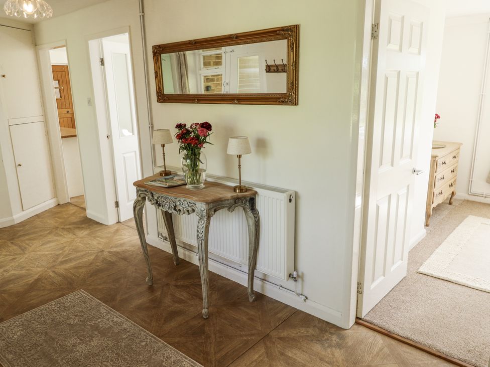 A hallway with a console table and mirror at Lake View Cottage in Well near Alford