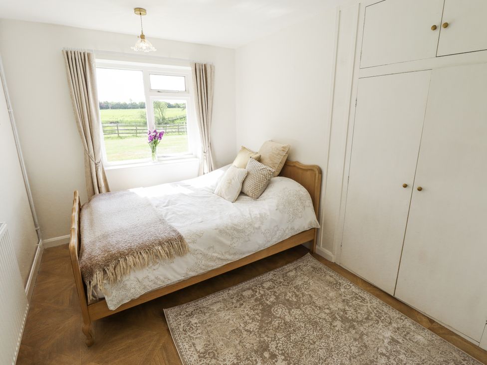 A bedroom with a bed and a window at Lake View Cottage in Well near Alford