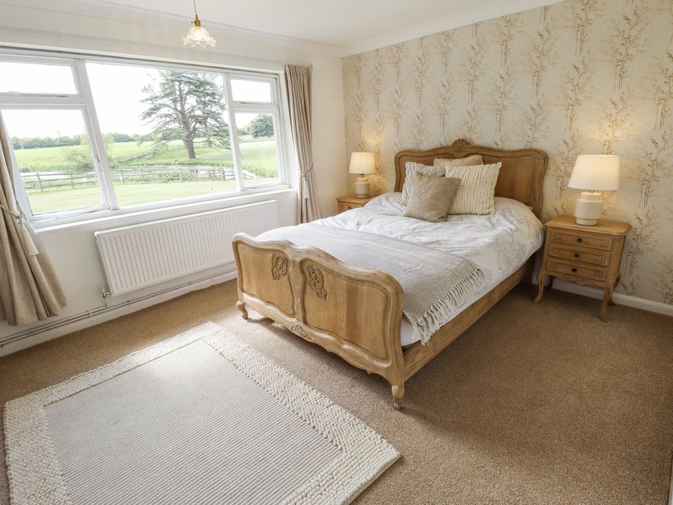 A bedroom with a bed and bedside tables at Lake View Cottage Well near Alford