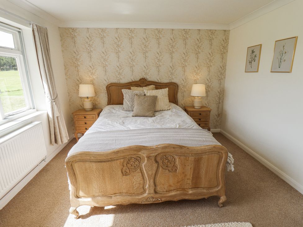 A bedroom with a bed and nightstands at Lake View Cottage in Well near Alford
