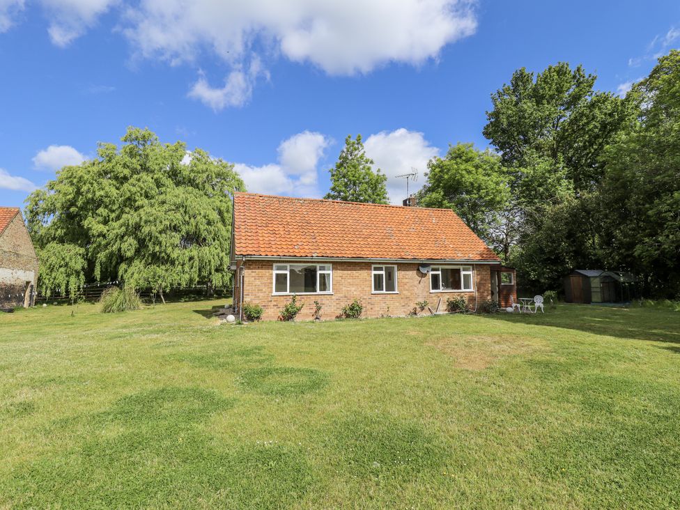A house with a garden and trees at Lake View Cottage in Well near Alford