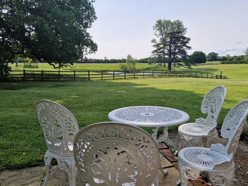 A table and chairs on a green lawn at Lake View Cottage Well near Alford