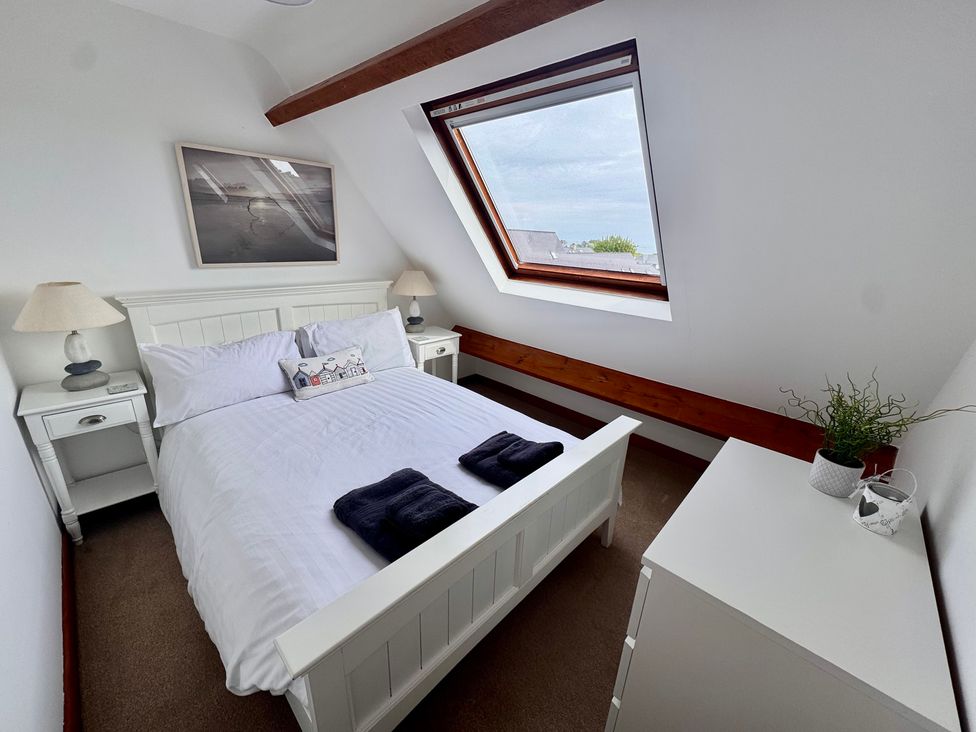 A bedroom with a bed and side tables at 220 Cae Du in Abersoch