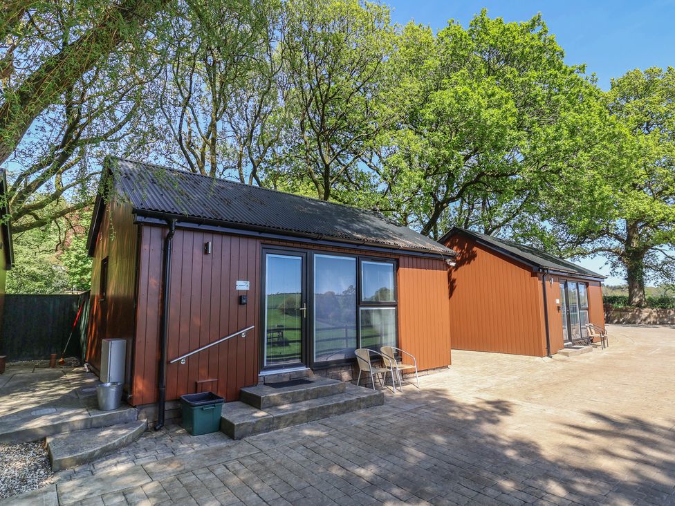 A cabin with patio area and chairs at Jasmine in Bydown near Barnstaple