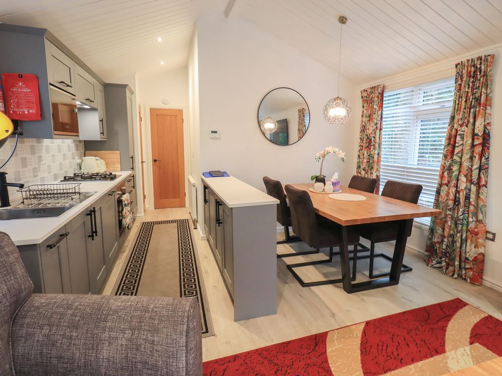 A dining room with a table and chairs at Merewood in Troutbeck Bridge