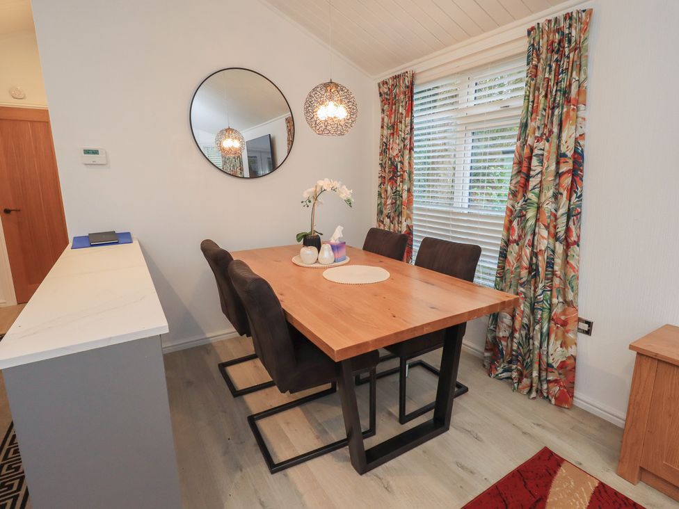 A dining room with a table and chairs at Merewood in Troutbeck Bridge