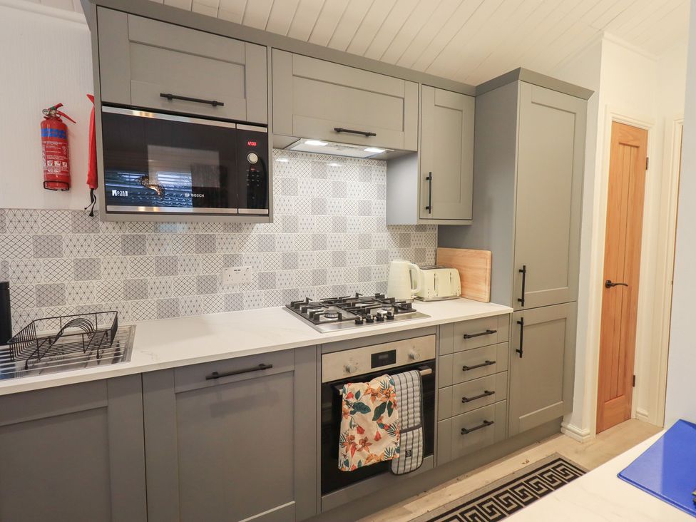 A kitchen with cabinets and appliances at Merewood in Troutbeck Bridge