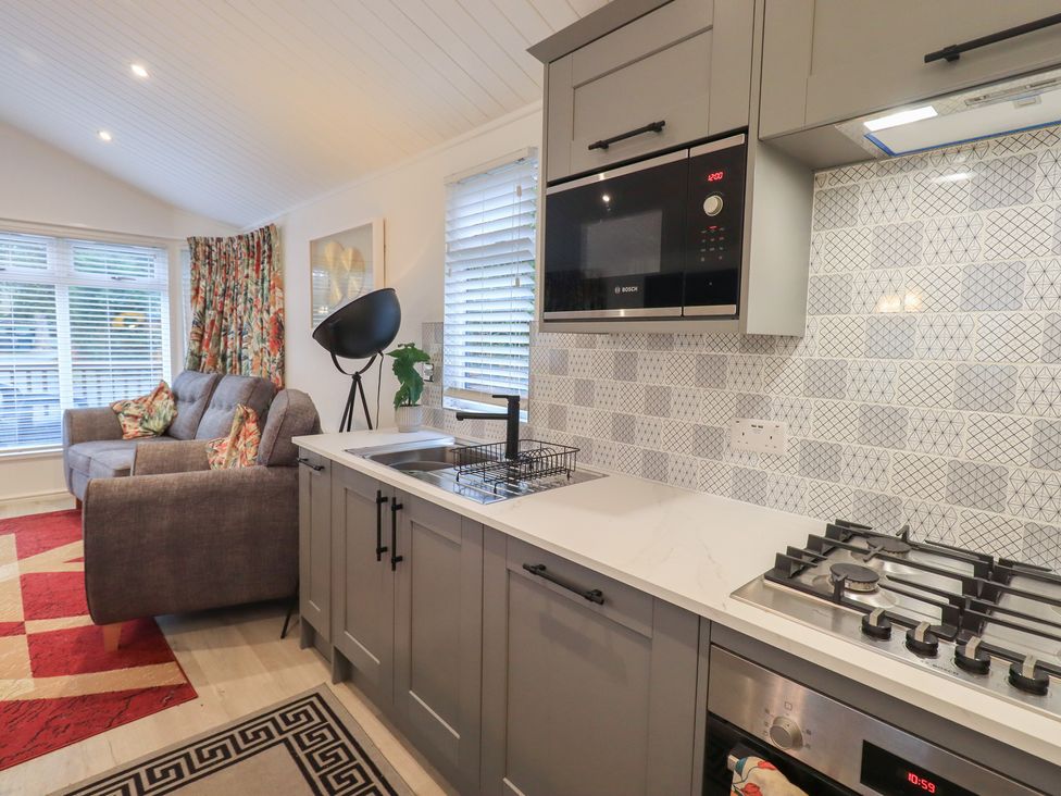 A kitchen with a sofa and microwaves at Merewood in Troutbeck Bridge