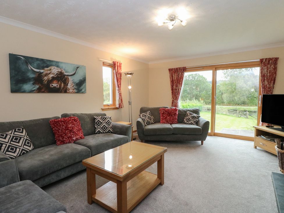 A living room with sofas and a television at Maybank in Muirshearlich