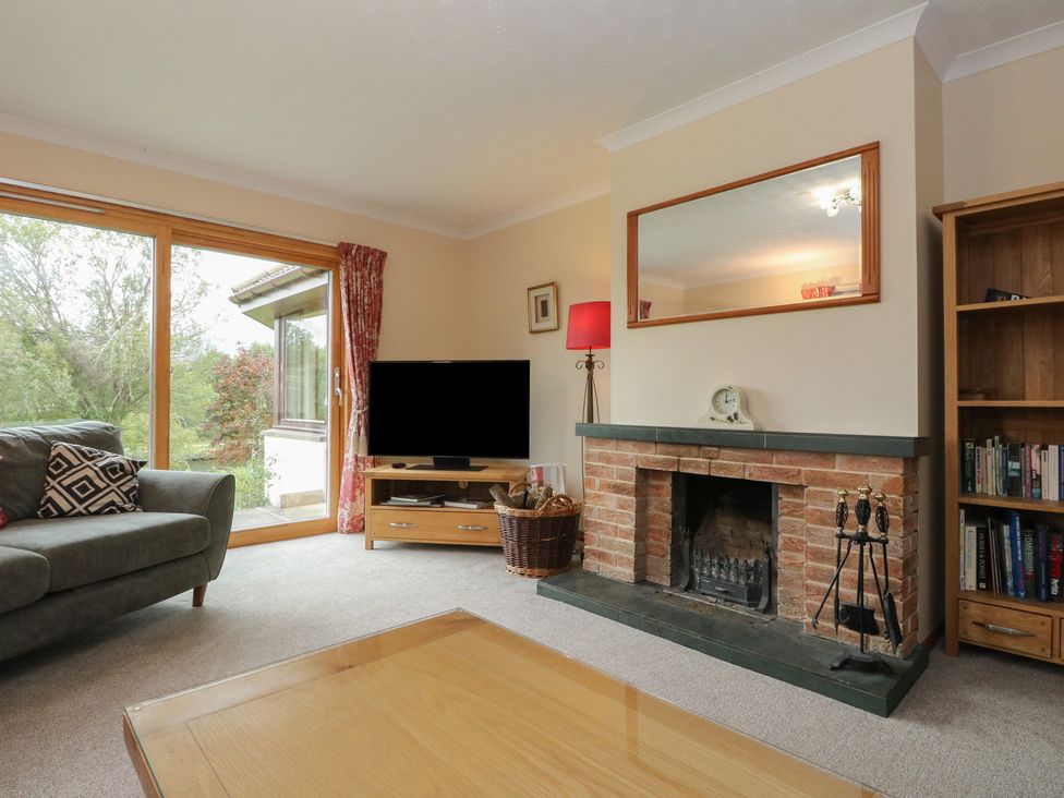 A living room with a television and fireplace at Maybank in Muirshearlich