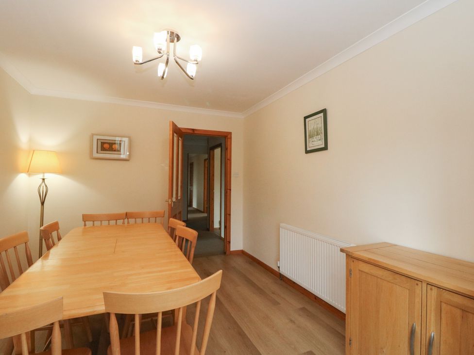 A dining room with a table and chairs at Maybank in Muirshearlich