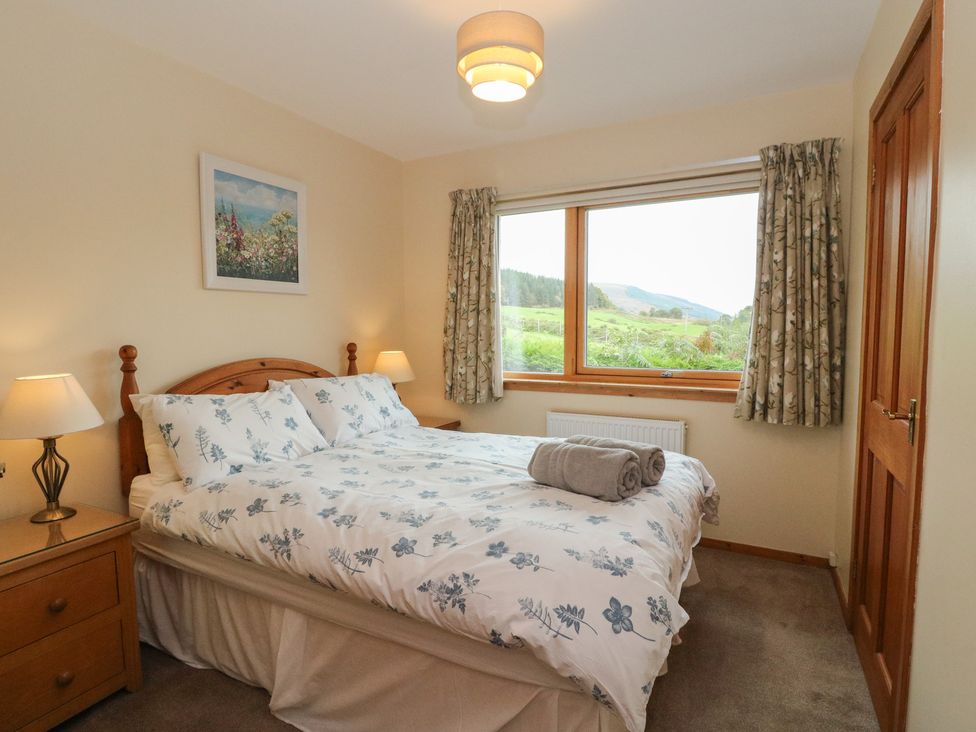 A bedroom with a double bed and a window at Maybank in Muirshearlich