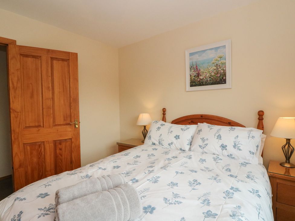 A bedroom with a double bed and nightstands at Maybank in Muirshearlich