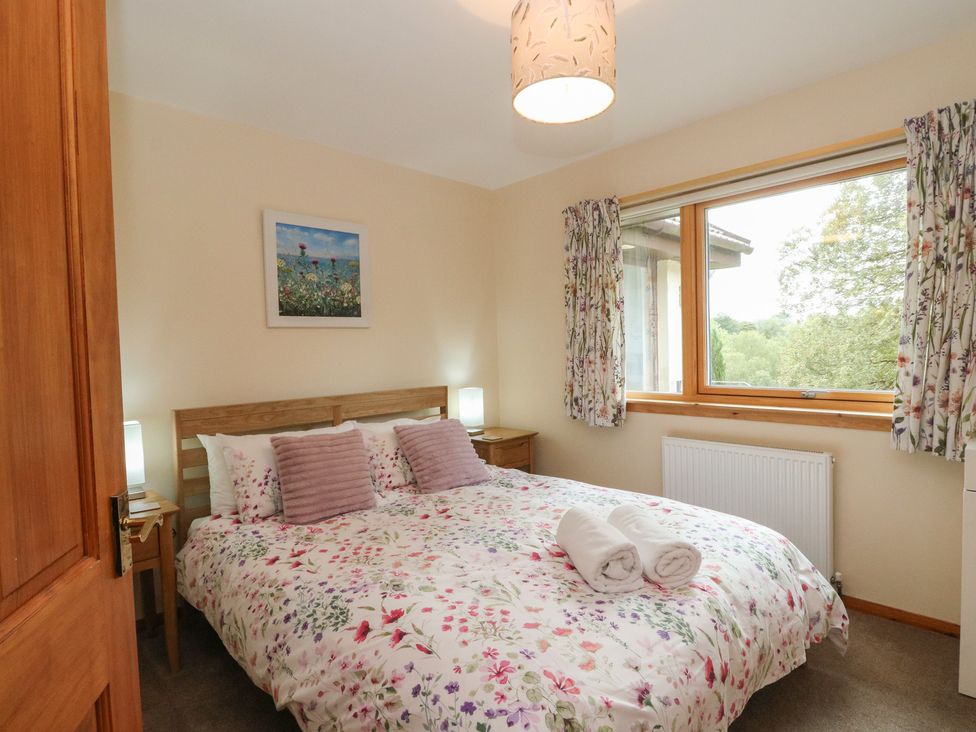 A bedroom with a double bed and wooden furniture at Maybank in Muirshearlich