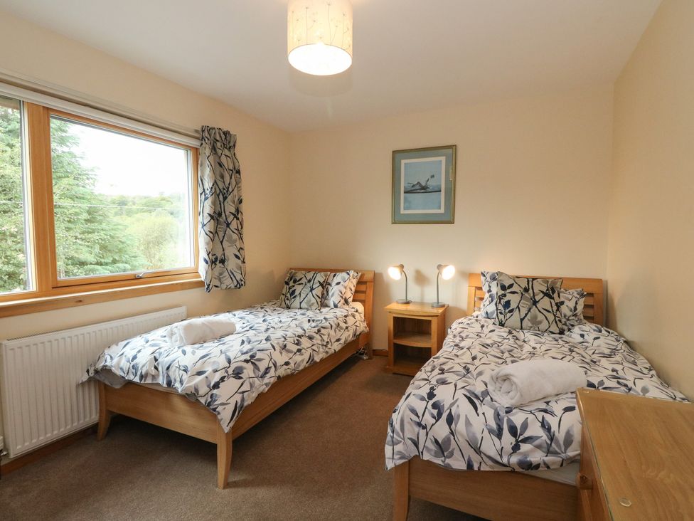 A bedroom with two single beds and a window at Maybank in Muirshearlich