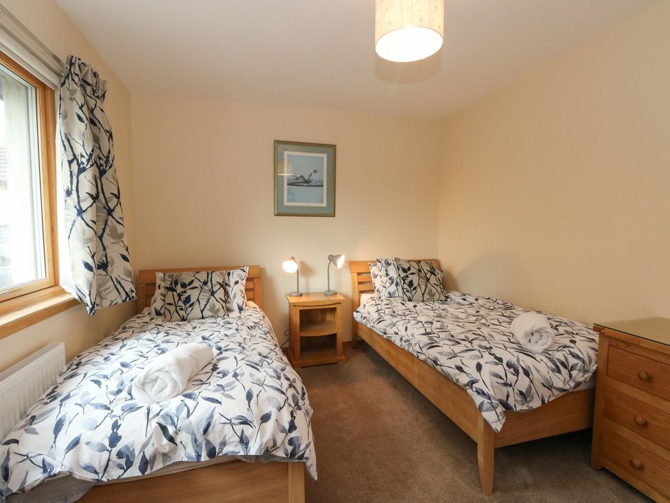 A bedroom with two beds and a window at Maybank in Muirshearlich