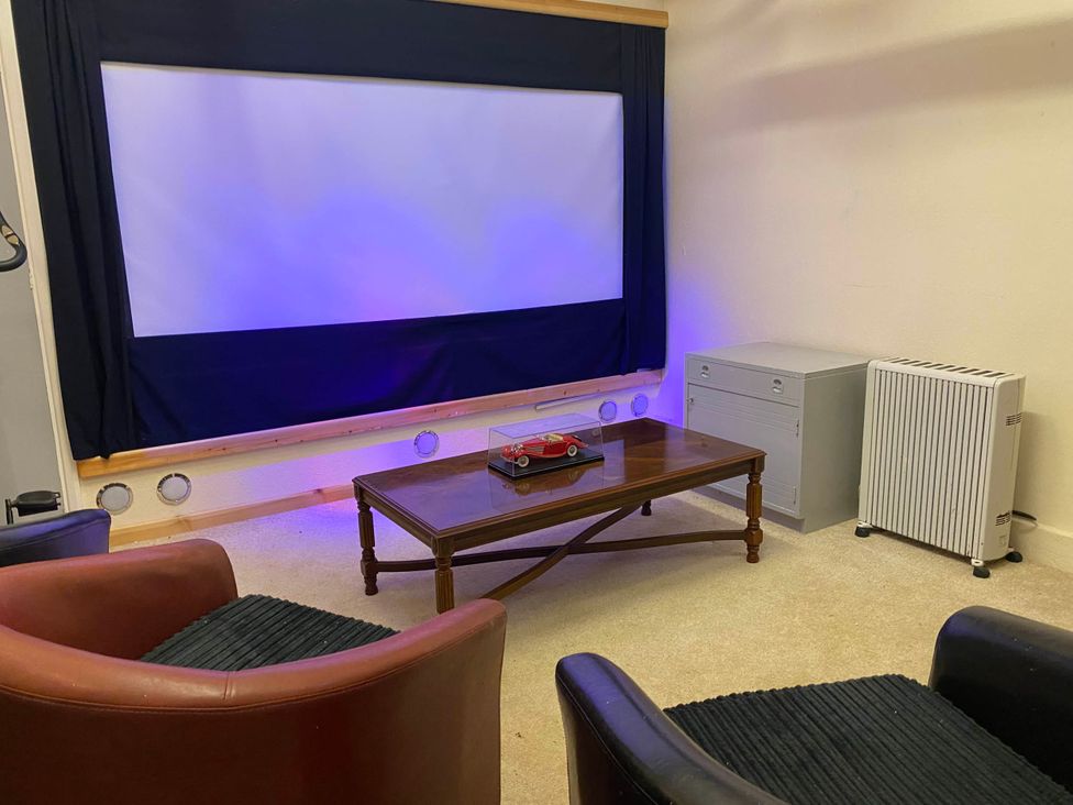 A home theater with a projection screen and seating at Llaethdy Cottage Castlemorris near Letterston