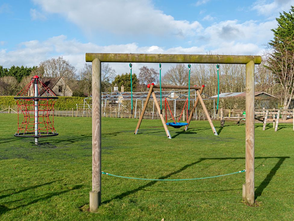 A playground with swings and climbing frame at Owl in Shobdon