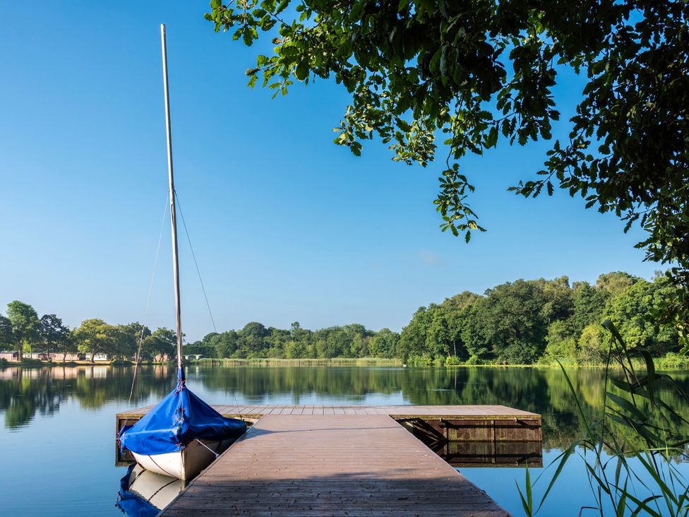 A dock with a boat at the edge of a lake at Owl in Shobdon