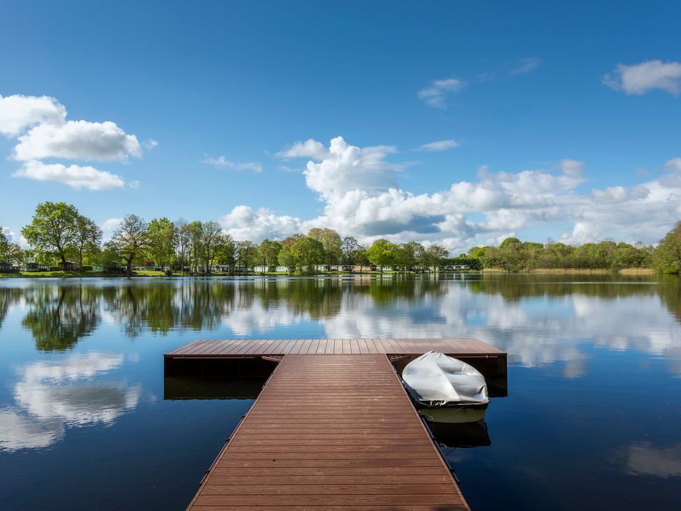 A dock with a boat on water at Owl in Shobdon