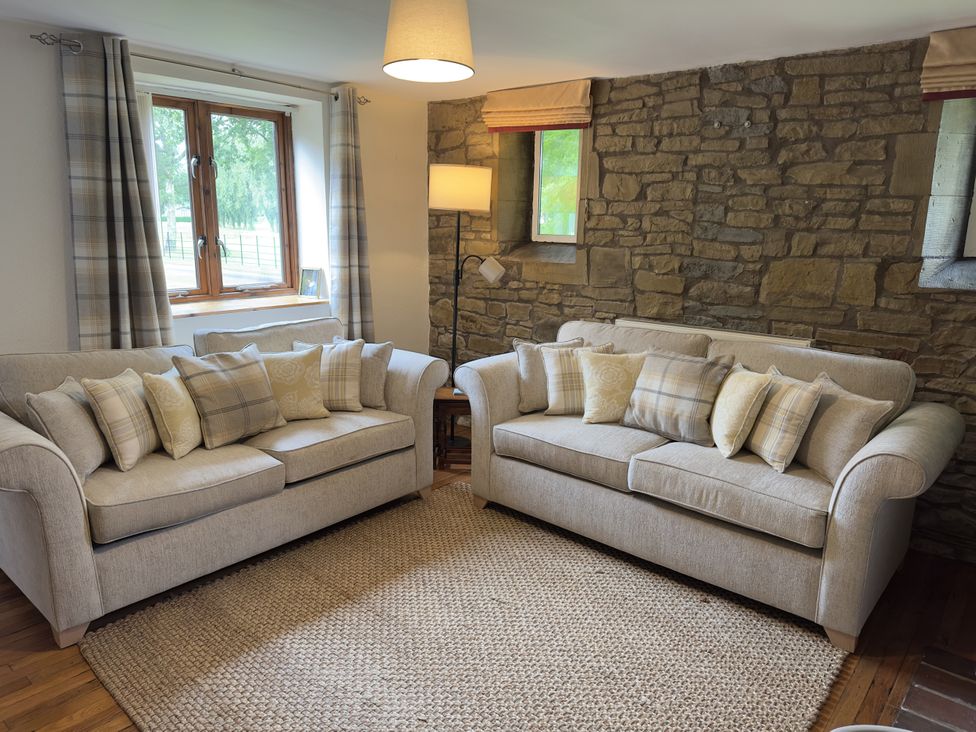 A living room with two sofas and a window at Stables Cottage in Shobdon