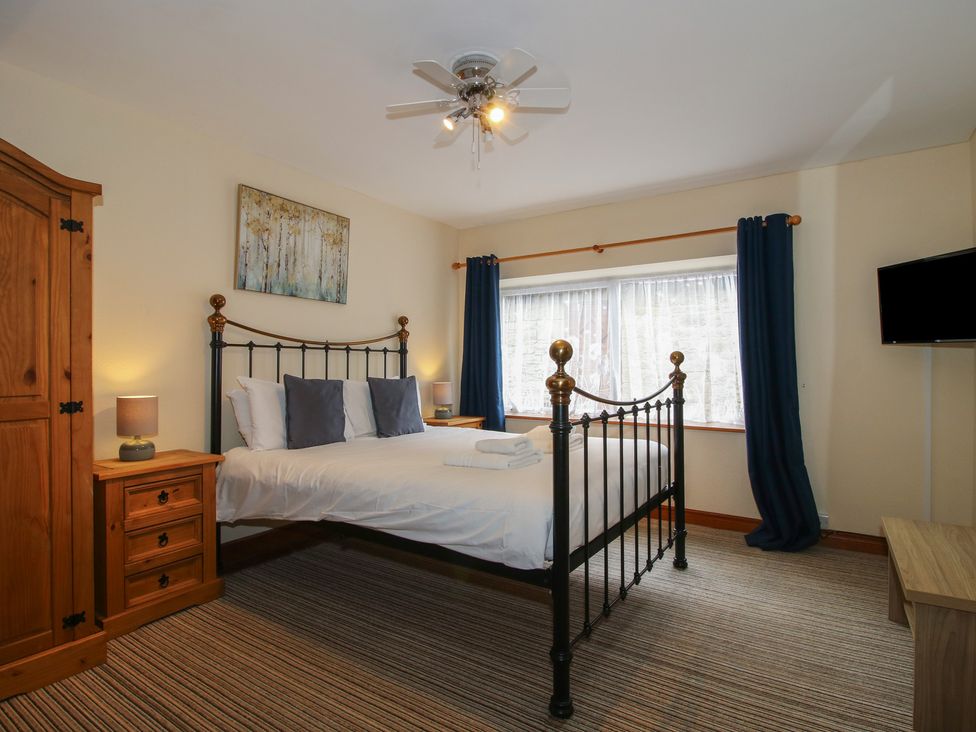 A bedroom with a bed and nightstand at Stables Cottage in Shobdon
