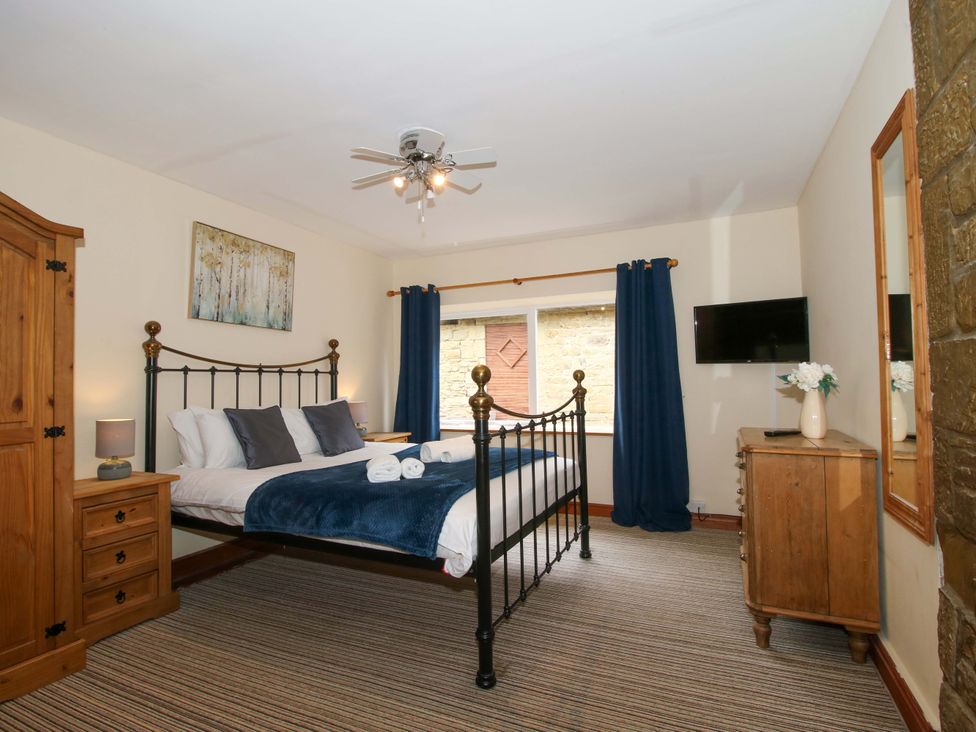 A bedroom with a bed and wardrobe at Stables Cottage in Shobdon