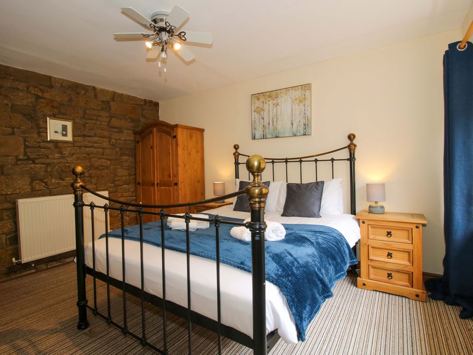 A bedroom with a bed and wardrobe at Stables Cottage Shobdon