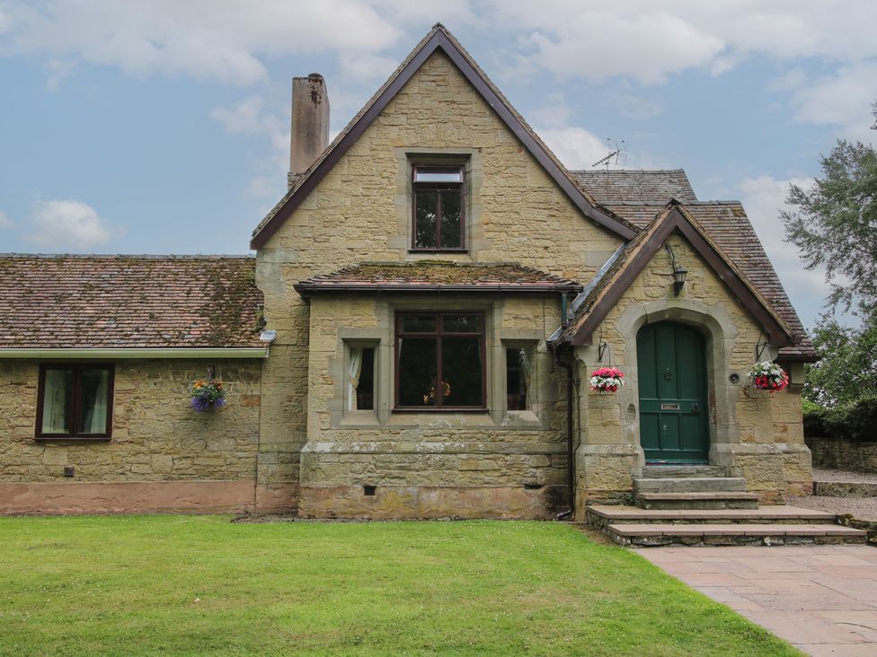 A house with a green door and windows at Keepers Cottage in Shobdon