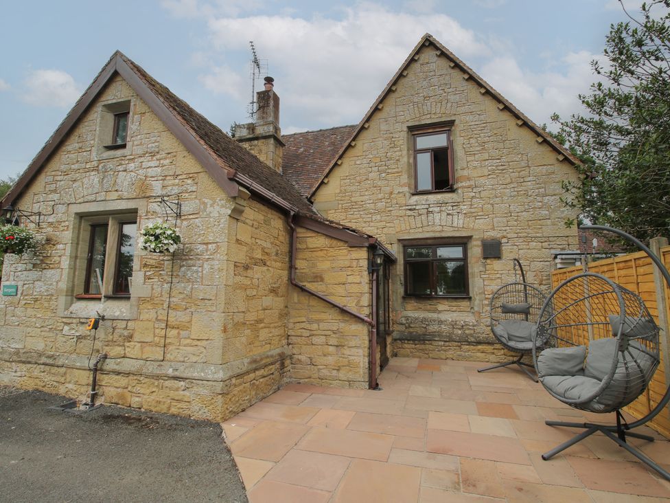 A house with patio and hanging chairs at Keepers Cottage in Shobdon