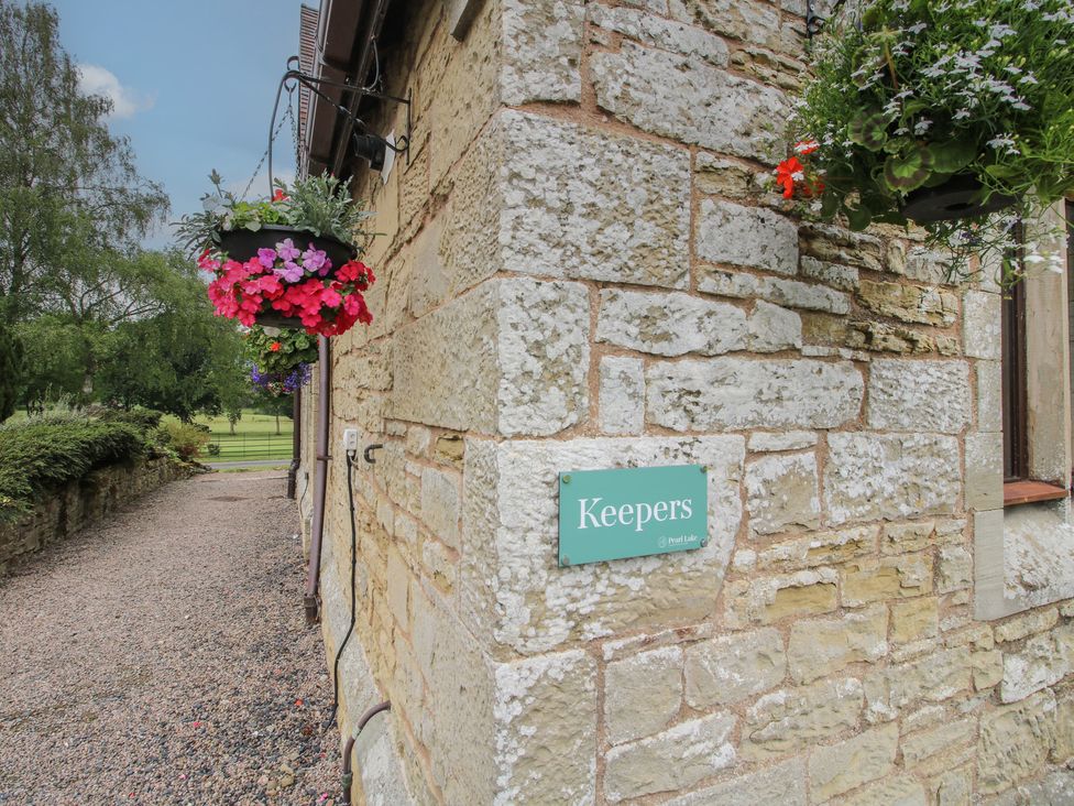 The exterior of Keepers Cottage with hanging planters in Shobdon
