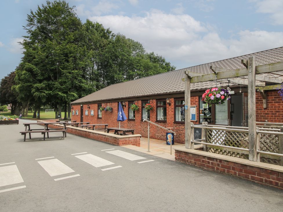 An outdoor area with benches and tables at Keepers Cottage Shobdon